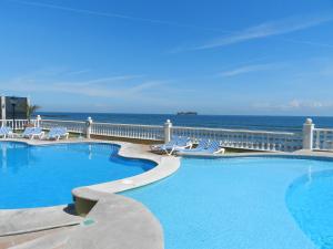 una piscina con sillas y el océano en el fondo en Hotel Villa Florida Veracruz, en Veracruz