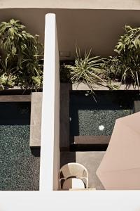 a chair sitting next to some potted plants at Istoria, a Member of Design Hotels in Perivolos