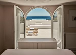 a bedroom with a view of the ocean at Istoria, a Member of Design Hotels in Perivolos