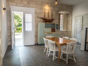 - une cuisine avec une table en bois et des chaises blanches dans l'établissement Beachfront 4-bedroom villa Sea Wave in Orebic, Croatia, à Orebić