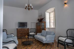 un salon avec des chaises bleues et une télévision dans l'établissement Beachfront 4-bedroom villa Sea Wave in Orebic, Croatia, à Orebić