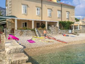 Un homme debout sur une plage à côté d'une maison dans l'établissement Beachfront 4-bedroom villa Sea Wave in Orebic, Croatia, à Orebić