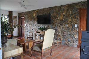 a living room with a stone wall at Posada La Serena in Tandil