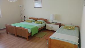- une chambre avec 2 lits et une table de nuit avec une lampe dans l'établissement Apartment Cecilia Koprivnica, à Koprivnica