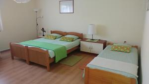 a bedroom with two beds and a night stand with a lamp at Apartment Cecilia Koprivnica in Koprivnica