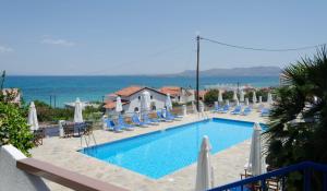 a swimming pool with blue chairs at The Boulas Rooms in Megalochori +40 photos