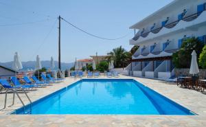 a swimming pool with chairs and a hotel at The Boulas Rooms in Megalochori