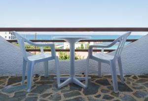 a table and two chairs sitting on a balcony at The Boulas Rooms in Megalochori