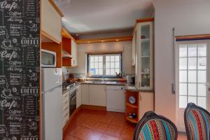 a kitchen with a chalkboard wall with a refrigerator at Like-home Boa Onda House-T4-Ericeira center in Ericeira