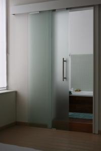 a glass shower door in a bathroom with a sink at Gîte La Maison du Vieux Pommier in Spa