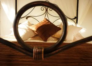 a bed with a wooden headboard and pillows at Aux Bords du Temps in Zonza