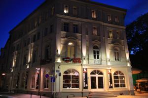 ein großes weißes Gebäude mit Licht an in der Unterkunft OPERA Hostel in Erfurt