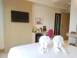 two white towels on a bed in a room at Kavin Buri Green Hotel in Udon Thani