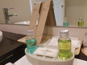 a bathroom with two bottles of soap and a mirror at Kavin Buri Green Hotel in Udon Thani