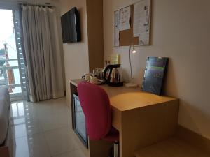 a desk with a pink chair in a hotel room at Kavin Buri Green Hotel in Udon Thani