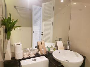 a bathroom with a sink and a toilet and a mirror at Kavin Buri Green Hotel in Udon Thani