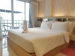 a bed with a stuffed animal sitting on top of it at Kavin Buri Green Hotel in Udon Thani