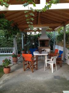 a patio with a table and chairs and a fireplace at Aggeliki-Smaro Studios in Neos Pirgos