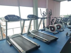 a gym with several cardio bikes and tread machines at Kavin Buri Green Hotel in Udon Thani