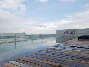 a boardwalk with a bench on top of a building at Kavin Buri Green Hotel in Udon Thani
