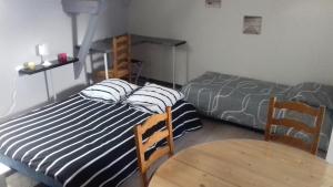 een slaapkamer met 2 bedden en een tafel en een bed bij Chez Jo et Anne-Marie in Balleroy