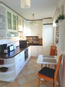 a kitchen with white cabinets and a table and chairs at Ferienwohnung Sonnenhaft in Baden-Baden