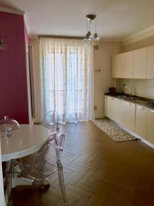 a kitchen with a white table and chairs and a window at B&B Civico22 in Torre Maggiore