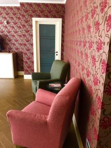 a living room with a pink couch and a chair at B&B Civico22 in Torre Maggiore