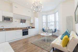 a kitchen and living room with a couch and a table at Maycourt Gem in London