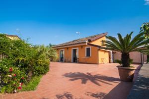 a house with palm trees and a brick driveway at B&B Villagata in Piedimonte Etneo