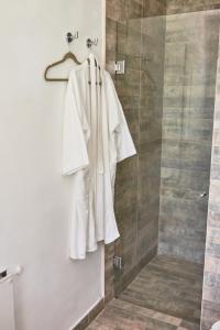 a white robe is hanging in a shower at Posada La Serena in Tandil