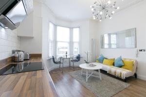 uma sala de estar com um sofá e uma mesa em Maycourt Gem em Londres