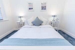 um quarto com uma grande cama branca e duas mesas em Maycourt Gem em Londres