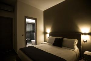 ナポリにあるGB Central Station Napoliのベッドルーム1室(壁に照明2つ付)