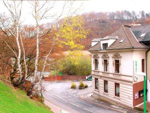 a building on a hill next to a street at Hotel Zum Deutschen Eck in Velbert