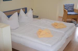 ヘリングスドルフにあるVilla Inge Appartement 11の白いベッド(タオル、椅子付)