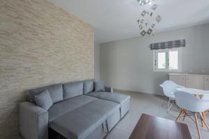 sala de estar con sofá y pared de ladrillo en Peristera, en Katelios