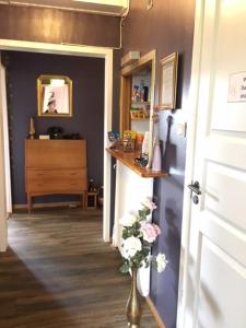 a hallway with a vase of flowers next to a door at Pensionat Augustin in Gällivare