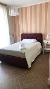 a bedroom with a large bed with a striped wall at B&B Civico22 in Torre Maggiore