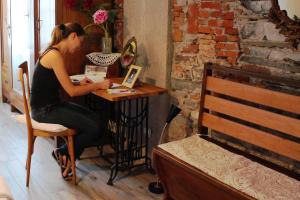 une femme assise à une table avec un ordinateur portable dans l'établissement Le Dame Della Cortesella B&B, à Côme