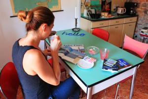 une femme assise à une table avec une machine à coudre dans l'établissement Le Dame Della Cortesella B&B, à Côme