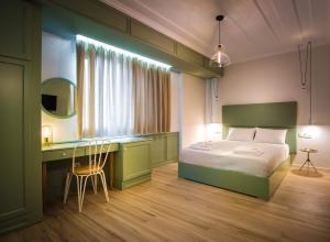 1 dormitorio con cama, escritorio y mesa en Allure Central Boutique Hotel, en Lefkada