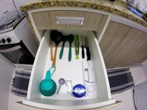a toy kitchen with utensils in a cabinet at Casa em Petropolis 7 min do Museu in Petrópolis
