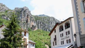 a mountain in the distance with two buildings and trees at Auberge Saint Martin in La Brigue