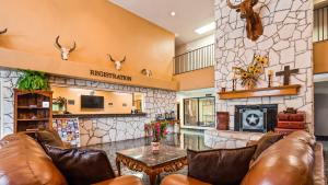 a living room with leather furniture and a fireplace at Texas Inn Beeville in Beeville