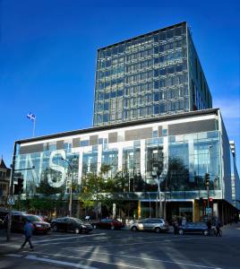 een groot glazen gebouw met auto's geparkeerd voor het bij Hôtel de l'ITHQ in Montreal