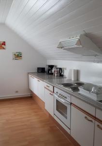 a kitchen with white cabinets and a stove top oven at Ferienwohnung Olpe Biggesee in Olpe