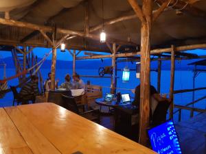 サンタ・アナにあるCaptain Morgan Hostel Lake Coatepequeのレストランのテーブルに座っている人々のグループ