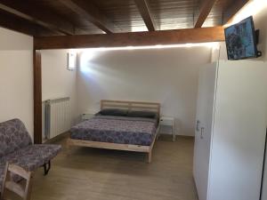 a bedroom with a bed and a chair and a refrigerator at I Villini in Pescara