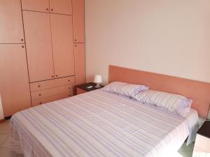 een slaapkamer met een bed met een gestreepte sprei bij I Giardini e Le Terrazze in Mascali